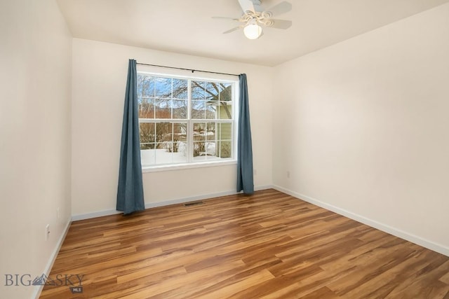 empty room featuring visible vents, baseboards, ceiling fan, and light wood finished floors