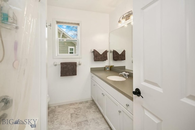 full bathroom with baseboards, toilet, and vanity