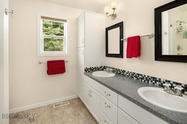 full bathroom featuring a sink, visible vents, baseboards, and double vanity