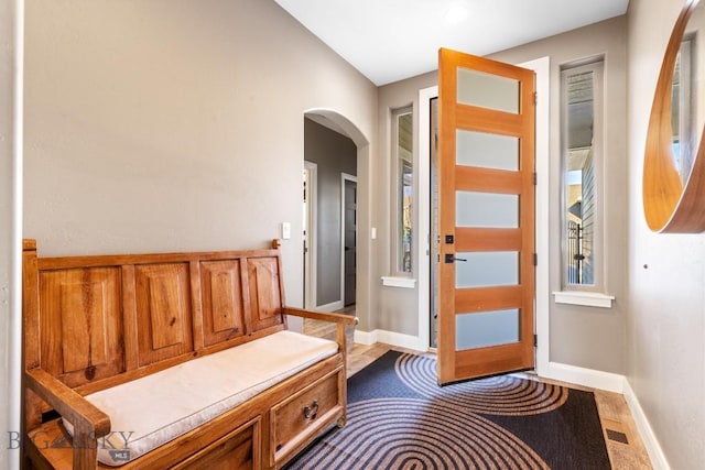 entryway featuring arched walkways and baseboards