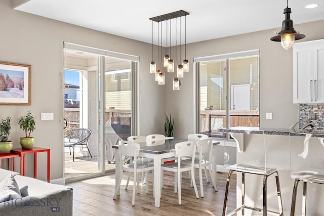 dining space with plenty of natural light and light wood-style floors