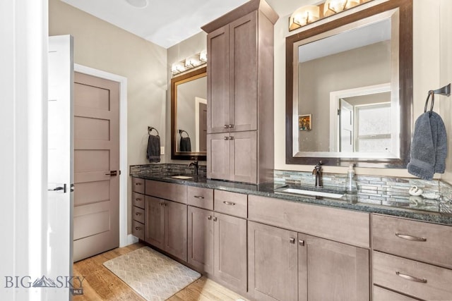 full bath with a sink, wood finished floors, and double vanity