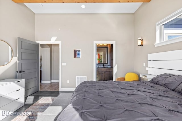 bedroom with visible vents, baseboards, dark wood-type flooring, and beam ceiling