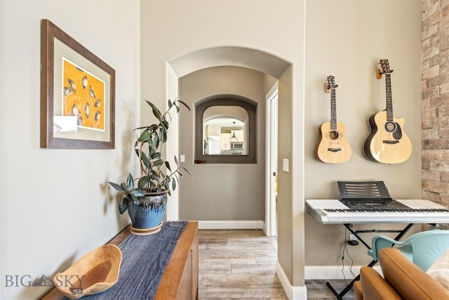 hallway featuring wood finished floors and baseboards