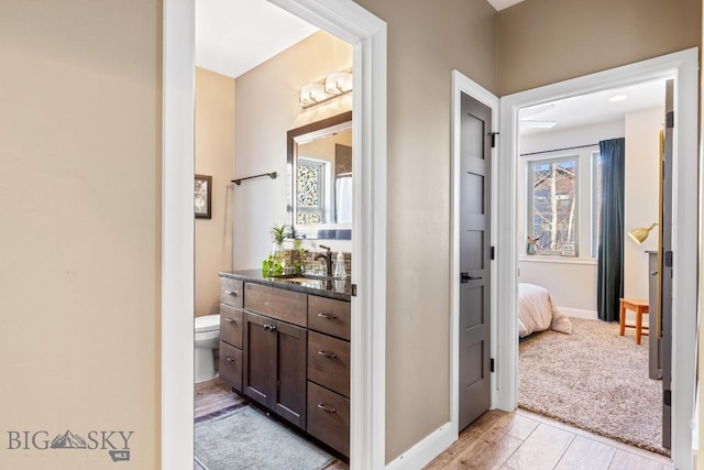 bathroom with baseboards, toilet, and vanity