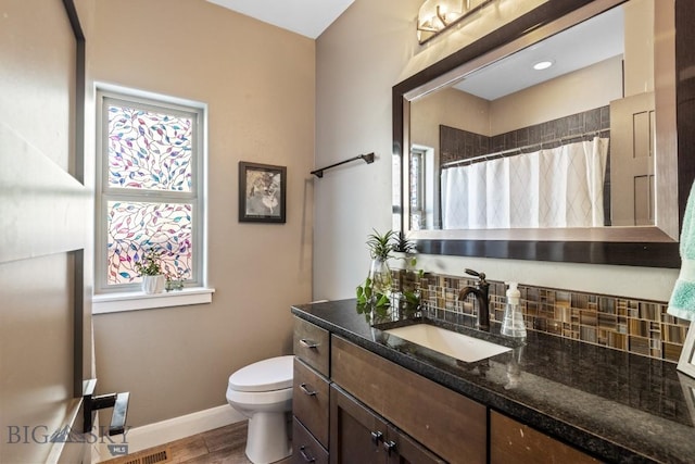 full bathroom featuring toilet, curtained shower, backsplash, baseboards, and vanity