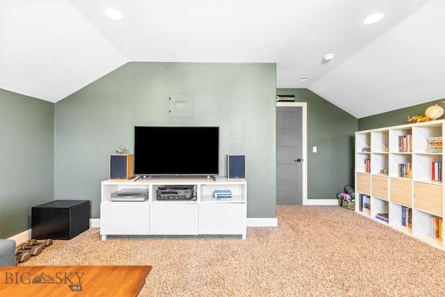 carpeted living room featuring baseboards and vaulted ceiling