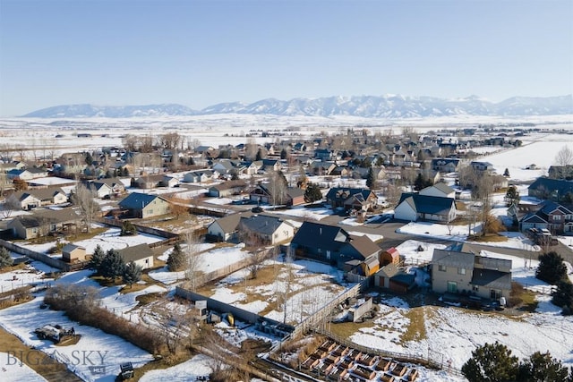 snowy aerial view featuring a residential view and a mountain view