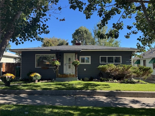 view of front of property featuring a front yard, fence, and a chimney