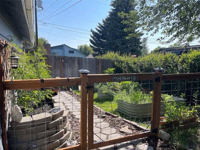 view of gate featuring a vegetable garden and fence