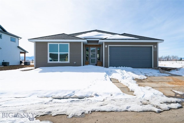 view of front of home with central AC unit and a garage