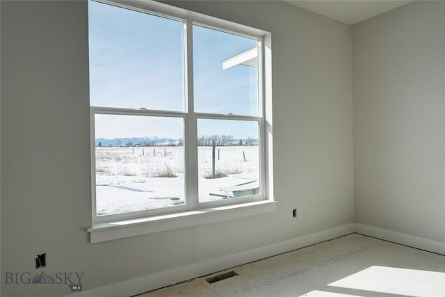 unfurnished room featuring visible vents, a healthy amount of sunlight, and baseboards