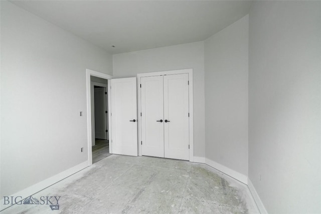 unfurnished bedroom with a closet and baseboards