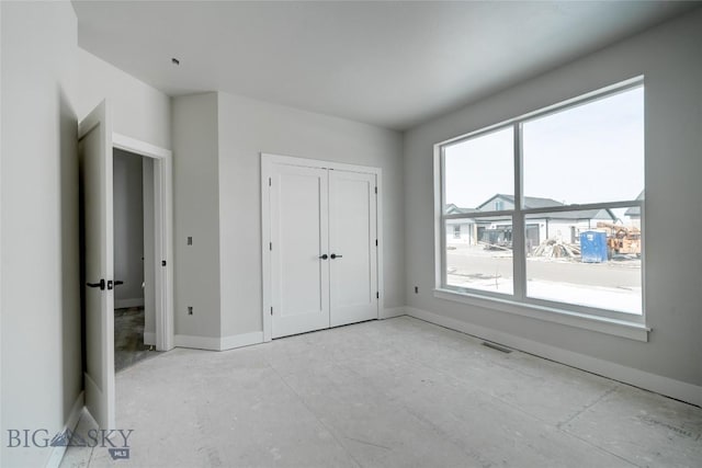 unfurnished bedroom featuring visible vents, baseboards, and a closet