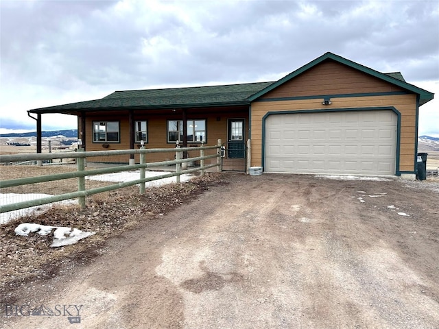 view of front of property featuring an outdoor structure, an attached garage, and driveway