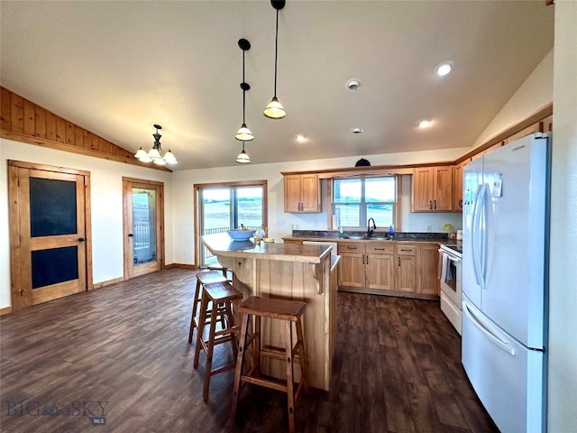 kitchen with a breakfast bar, dark wood-style floors, a center island, white appliances, and lofted ceiling