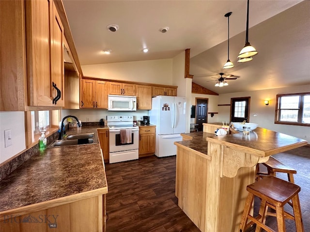 kitchen featuring white appliances, a breakfast bar, lofted ceiling, dark wood-style flooring, and a sink