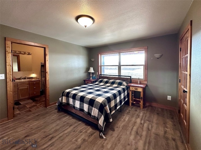 bedroom with a sink, dark wood-type flooring, and a textured ceiling