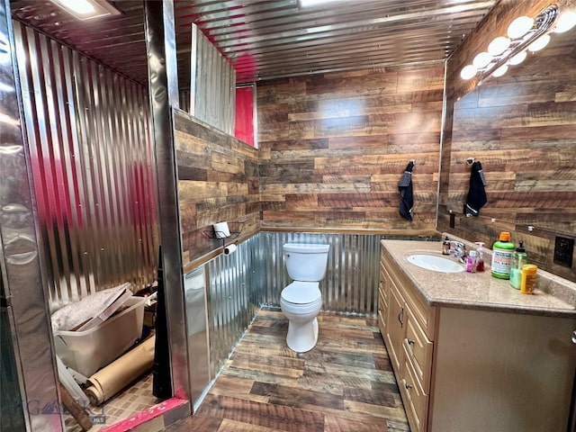 bathroom featuring toilet, wood finished floors, wood walls, wood ceiling, and vanity