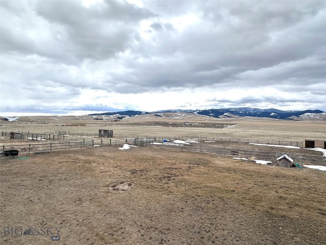 view of yard featuring fence, a rural view, and a mountain view