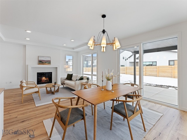 2824 S 30th Ave, Bozeman, MT 59718 - dining space featuring light wood-style flooring, a fireplace, a chandelier, recessed lighting, and a raised ceiling