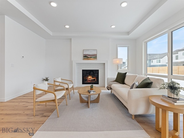 2824 S 30th Ave, Bozeman, MT 59718 - living room with light wood-type flooring, a tray ceiling, a brick fireplace, recessed lighting, and baseboards