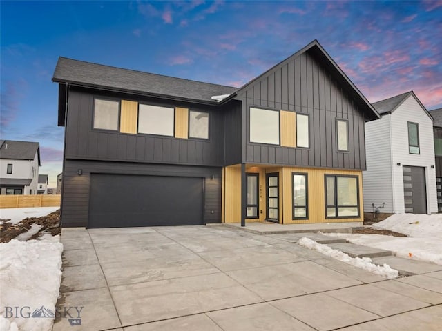 modern farmhouse featuring a garage, board and batten siding, and driveway