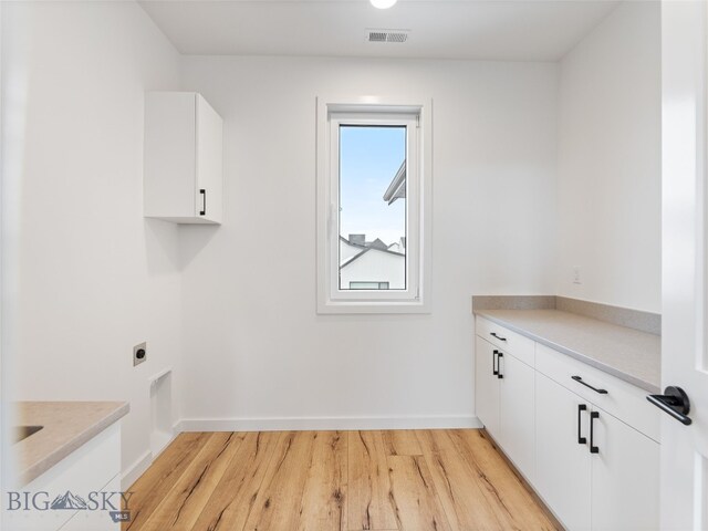 2824 S 30th Ave, Bozeman, MT 59718 - laundry area with cabinet space, hookup for an electric dryer, light wood finished floors, and baseboards
