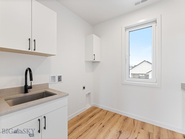 2824 S 30th Ave, Bozeman, MT 59718 - washroom featuring washer hookup, cabinet space, baseboards, light wood-style floors, and electric dryer hookup
