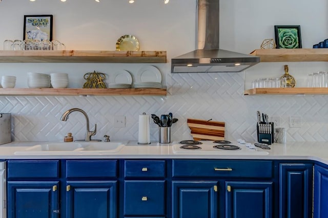 kitchen with blue cabinetry, open shelves, ventilation hood, white electric stovetop, and a sink