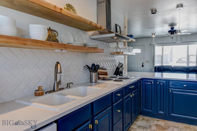 kitchen featuring open shelves, blue cabinetry, a sink, range hood, and stovetop