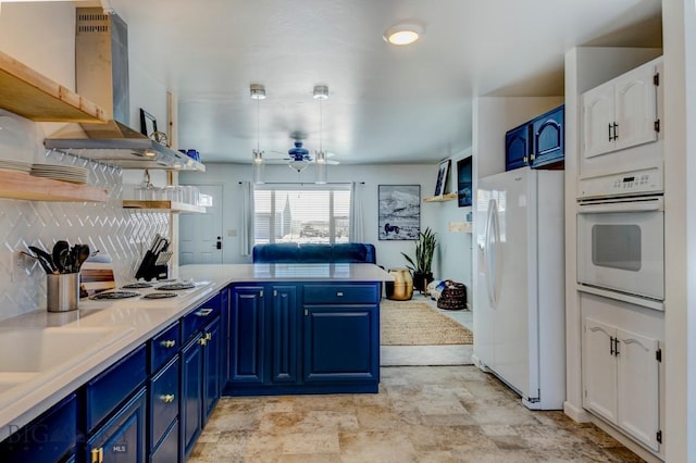 kitchen with blue cabinets, a peninsula, white appliances, wall chimney exhaust hood, and open shelves