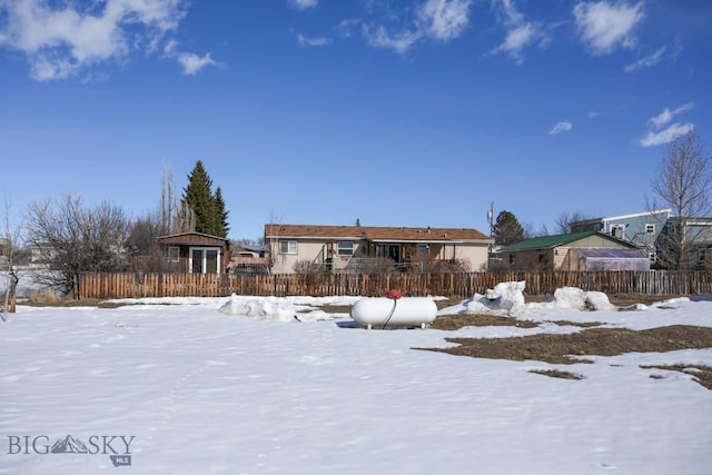 snow covered house with fence