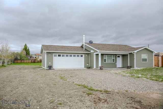 305 Lathrop St W, Clyde Park, MT 59018 - ranch-style house with an attached garage, fence, gravel driveway, and a shingled roof