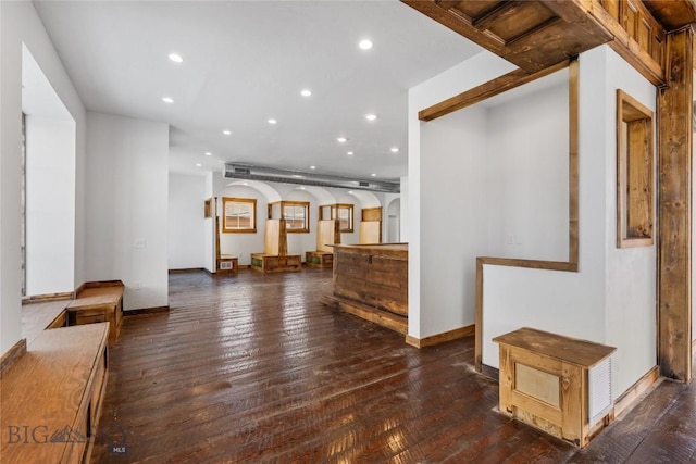 living area with arched walkways, recessed lighting, baseboards, and hardwood / wood-style floors