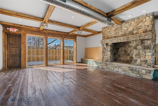 unfurnished living room with visible vents, coffered ceiling, a stone fireplace, hardwood / wood-style flooring, and beamed ceiling