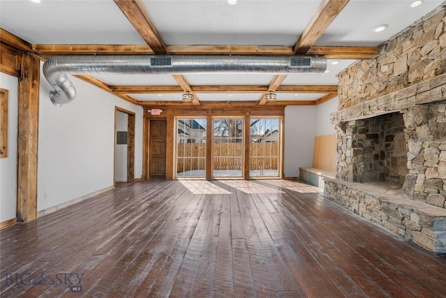 unfurnished living room with visible vents, baseboards, beam ceiling, a stone fireplace, and wood-type flooring