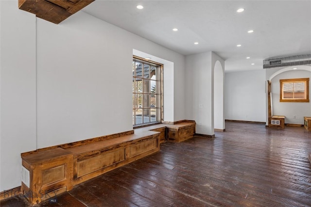 unfurnished room with visible vents, baseboards, recessed lighting, arched walkways, and hardwood / wood-style flooring