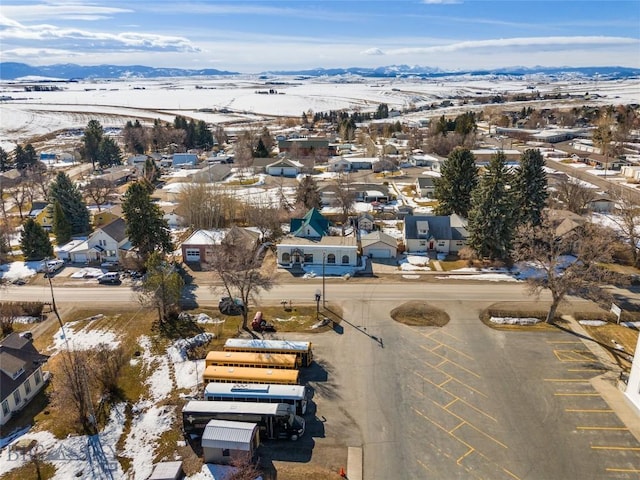 snowy aerial view featuring a residential view and a mountain view