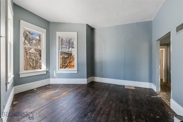 empty room featuring baseboards and hardwood / wood-style floors