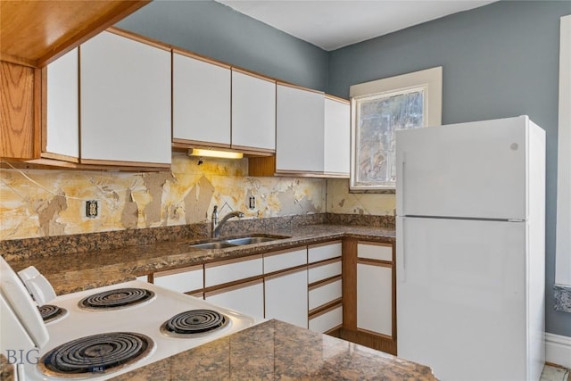 kitchen featuring backsplash, white cabinets, white appliances, and a sink