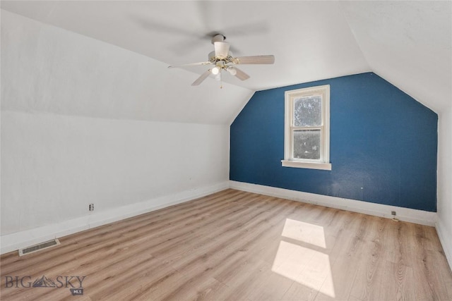 additional living space featuring visible vents, wood finished floors, baseboards, lofted ceiling, and ceiling fan