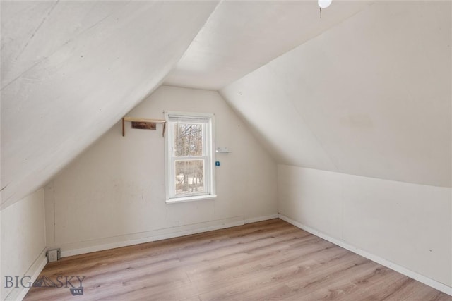 bonus room featuring wood finished floors and vaulted ceiling