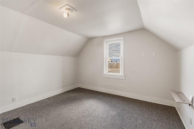 additional living space featuring vaulted ceiling, baseboards, visible vents, and carpet floors