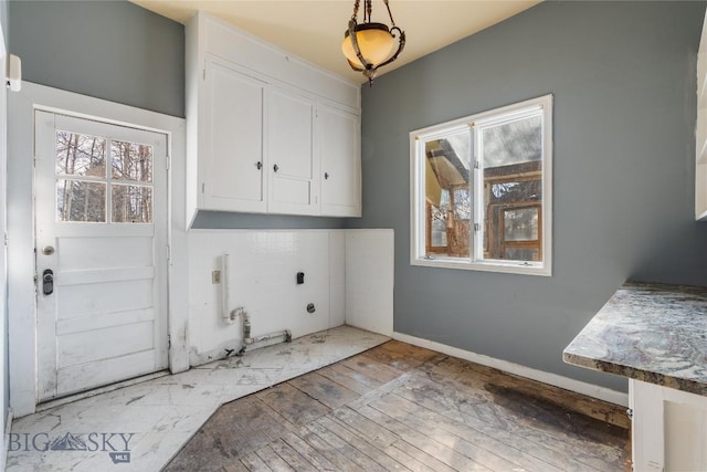 washroom with cabinet space, hookup for an electric dryer, wood-type flooring, and hookup for a gas dryer