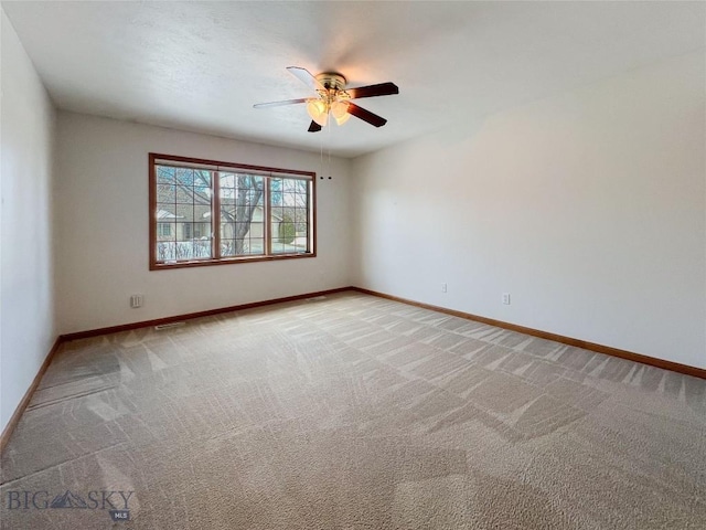 empty room with baseboards, light carpet, and ceiling fan