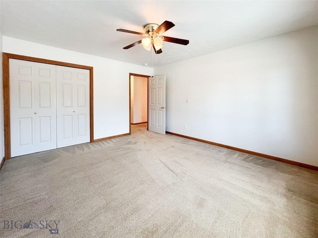 unfurnished bedroom with a ceiling fan, baseboards, a closet, and light carpet