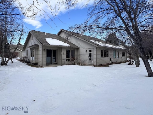 view of snow covered rear of property