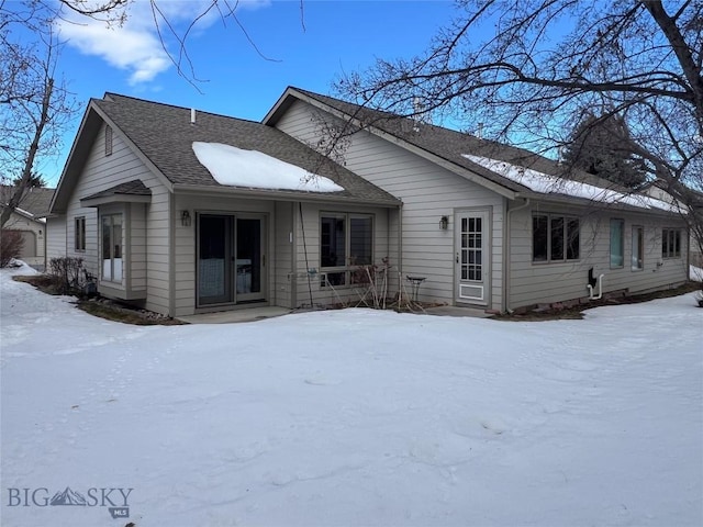 snow covered house with roof with shingles