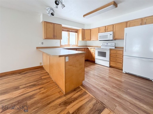 kitchen with white appliances, baseboards, light wood-type flooring, and a peninsula